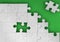 Fitting last puzzle piece on green background