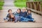 Five adorable kids, dressed in striped shirts, sitting on a bridge in the park