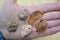 Five Agate Rocks on Palm with Holes Drilled for Jewelry Making