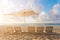 Five Beach chairs and Umbrella on the white sand beach with cloudy blue sky and sun