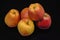 A five beautiful yellow with red spots of ripe apples on a black background