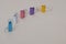Five binder clips of different colors on a gray background as characters standing next to each other, selective focus