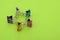 Five binder clips of different colors on a green paper background making star figure by holding hands, selective focus