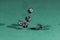 Five black dices falling on a green table