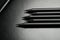 Five black pencils over black