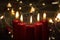 Five burning candles with blurred Christmas light