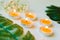 Five burning candles with small bouquet and green leaves on white background. Relaxation and aromatherapy concept