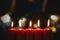 Five burning Christmas candles with blurred lights