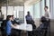 Five business people sitting at a conference table and discussing during a business meeting