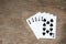 Five card of black spade royal straight flush on wood background