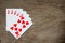 Five card of red heart royal straight flush on wood background