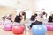 Five Caucasian Female Athletes Having Stretching Exercises with Fitballs Indoors