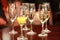 Five champagne flutes with champagne and bucks fizz