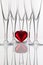 Five champagne glasses and red heart on a glass desk