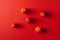 Five cherry tomatoes on a red background.