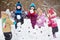 Five children build wall from snow bricks