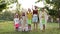 Five Children In The Garden In Costumes Of Indians. Children Stand From The Smallest To The Largest And Jump At The Same