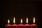 Five Christmas candles in dark background