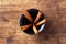 Five cinnamon sticks in cup on old wooden background.