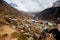 Five colored buddhist prayer flags hanging from cairns-stacked stones.