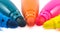 Five colorful pens on a white background - yellow, pink, orange, green and blue