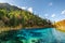 The Five Coloured Pool with azure water among autumn woods