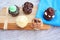 Five cupcakes on cutting board on wooden background