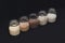 Five different types of cereals in jars on a black background. Porridge. Healthy food