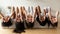 Five diverse girls wear pyjamas lying on bed upside down