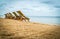 Five empty green beach chairs facing the ocean