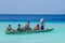 Five fishermen paddling a wooden boat