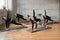 Five fitnesswomen practicing stretching on mats.