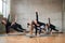 Five fitnesswomen practicing stretching on mats.