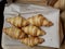 Five fresh croissants lying on a package from the bakery. delicious pastries sunny day