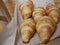 Five fresh croissants lying on a package from the bakery. delicious pastries sunny day