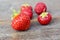 Five fresh red strawberries on wooden table. Clean, delicious and ready to eat.