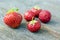 Five fresh red strawberries on wooden table. Clean, delicious and ready to eat.