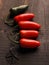 Five freshly harvested homegrown hot peppers on a rustic kitchen table