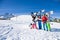 Five friends holding snowboards and skies together