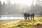 Five friends walking near a lake take in view, one points