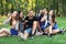 Five friends women and men inflate soap bubble outdoors