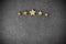 Five golden stars on dark background, top rating concept