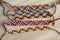 Five handmade homemade colorful natural woven bracelets of friendship on wooden board, checkered pattern
