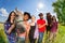 Five happy horseback riders in summer meadow