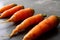 Five homegrown carrots on chalkboard