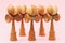 Five Japanese wooden Kendama toys on a pink background