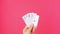 Five of a kind Poker Game cards in gambler hand pink background. Lucky combination Aces and Joker revealing. Online gambling 4K