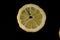 Five lemon slices lined up in a semicircle on a black background isolated