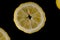 Five lemon slices lined up in a semicircle on a black background isolated