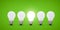 Five light bulbs in a row, center light bulb is brightly lit. Green background.
